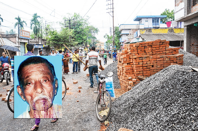 রাস্তার উপরে ফেলে রাখা হয়েছে ইট, স্টোনচিপসের স্তূপ, যে জন্য ঘটে দুর্ঘটনা। দুর্ঘটনার পরে বাঁশের ব্যারিকেড দিয়ে অবরোধ। ইনসেটে মৃত কালীপদ বিশ্বাস। ছবি: তাপস ঘোষ।