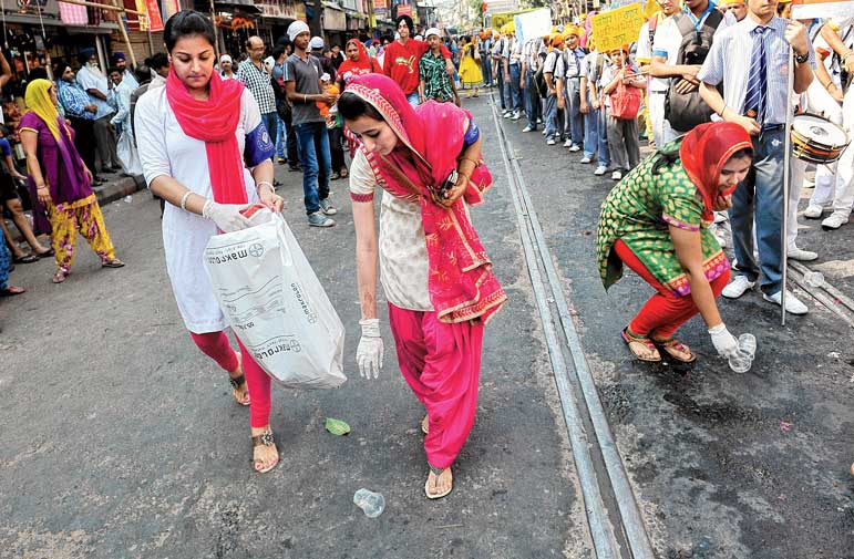 মিছিলের মধ্যেই চলছে রাস্তা সাফাই। রবিবার। ছবি: সুমন বল্লভ।