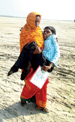 পঙ্গু ছেলে কোলে চর ভেঙে মাধ্যমিকের পরীক্ষাকেন্দ্রে মা