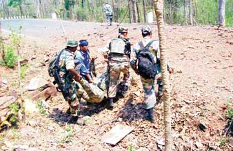 সহকর্মীর দেহ সরিয়ে নিয়ে যাচ্ছেন জওয়ানরা। শনিবার দরভায়। —নিজস্ব চিত্র
