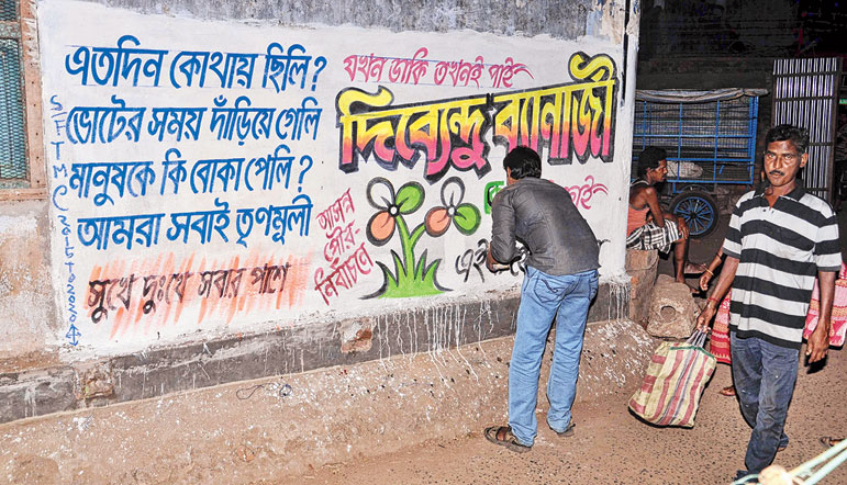 বিষ্ণুপুরে রাতেও চলছে দেওয়াল লিখন।—নিজস্ব চিত্র।