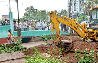 ভেঙে ফেলা হচ্ছে নিকাশি নালার উপরে থাকা নির্মাণ। —নিজস্ব চিত্র।