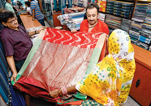 ঈদের বাজারে সাত্তোরের নির্যাতিতাকে শাড়ি কিনে দিচ্ছেন বিজেপি নেতা জয় বন্দ্যোপাধ্যায়। মঙ্গলবার কলকাতায় বিশ্বনাথ বণিকের তোলা ছবি