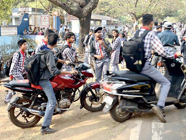 School students are riding bikes without helmet and license