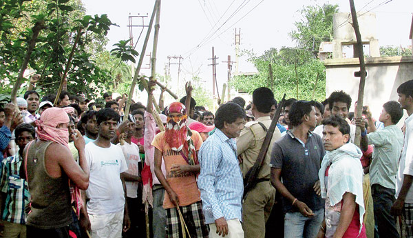 রাতে হামলার পরে মঙ্গলবার সকালে মাধাইপুরে লাঠি হাতে মিছিল গ্রামবাসীদের।