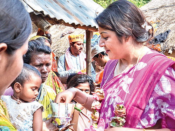 এগিয়ে আসা মুড়ির ঠোঙায় ভাগ বসালেন হাসিমুখে। বাজিতপুরে লকেট চট্টোপাধ্যায়। ছবি: সব্যসাচী ইসলাম।