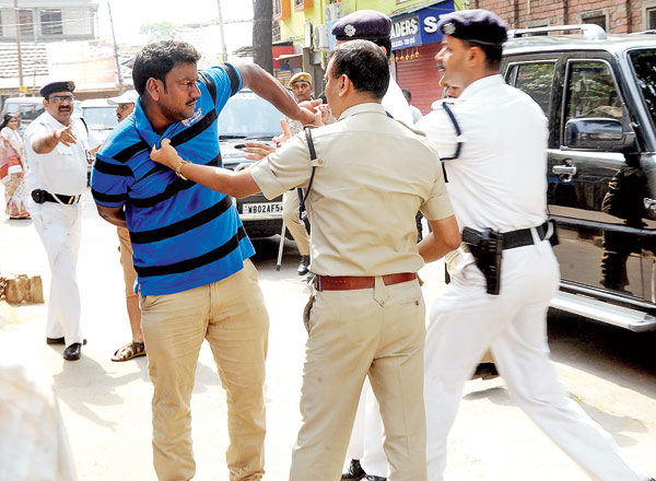 বেলেঘাটার শান্তি সঙ্ঘ স্কুলের কাছে একটি বুথের বাইরে ভোটারদের হুমকি দিতে দেখে সক্রিয় পুলিশ। বৃহস্পতিবার। ছবি: দেশকল্যাণ চৌধুরী।