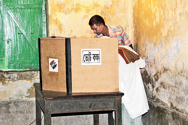 বর্ধমানের গোদার একটি বুথে এক জন ভোট দেওয়ার সময়ে হাজির অন্য জন। ছবি: উদিত সিংহ।