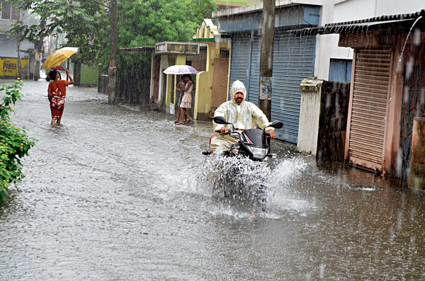 জল ভেঙেই যাত্রা। ব়ৃষ্টির জেরে পাড়ার রাস্তায় এভাবেই চলছে যাতায়াত।