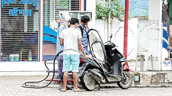 হেলমেট ছাড়া পাম্পেও লুকিয়ে চুরিয়ে মিলছে তেল। নিজস্ব চিত্র।