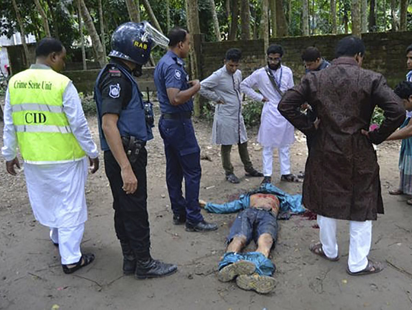 কিশোরগঞ্জে গুলির লড়াইতে নিহত জঙ্গির দেহ ঘিরে পুলিশ কর্মীরা। ছবি: এএফপি।