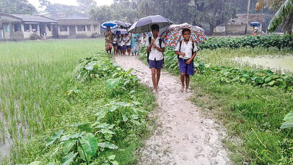 কাদা পায়ে স্কুলের পথে। ছবি: দিলীপ নস্কর।