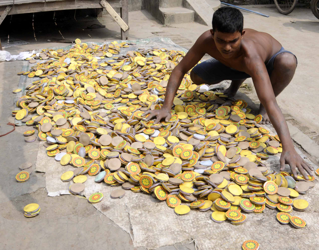 বাজি তৈরির কাজে হাত লাগিয়েছে চম্পাহাটি গ্রামের এক তরুণ।
