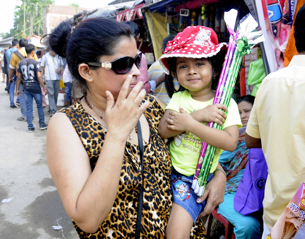 মুখে যেন বিজয়ীর হাসি। পছন্দ মতো বাজি পেয়ে এ বার বাড়ির পথে খুদে। ছবি: শশাঙ্ক মণ্ডল।