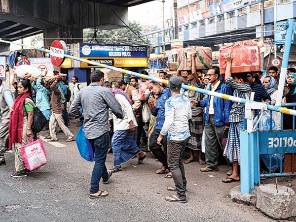 পারাপার: পথচারীদের নিয়ন্ত্রণ করতে বসানো হয়েছে লেভেল ক্রসিংয়ের মতো এই গেট। স্ট্র্যান্ড রোড ও মহাত্মা গাঁধী রোডের মোড়ে। —নিজস্ব চিত্র।