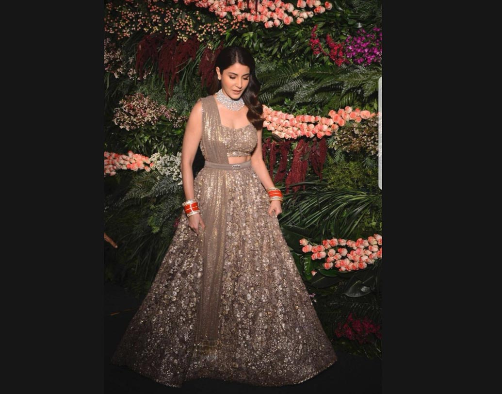 পিঙ্ক, রেডের পর রিসেপশনের জন্য অনুষ্কা বেছেছেন গ্রে কালার। সব্যসাচী মুখোপাধ্যায়ের ডিজাইন করা স্মোকি গ্রে রঙের লেহঙ্গার সঙ্গে কোমরে পরেছেন ‘বেঙ্গল টাইগার’ বেল্ট। সঙ্গে লখনউের শিল্পীদের হাতে করা ওড়না।দু’হাতে সাবেকি পঞ্জাবি চুড়া। গলায় রোজ কাট ডায়মন্ডের নেকলেস।