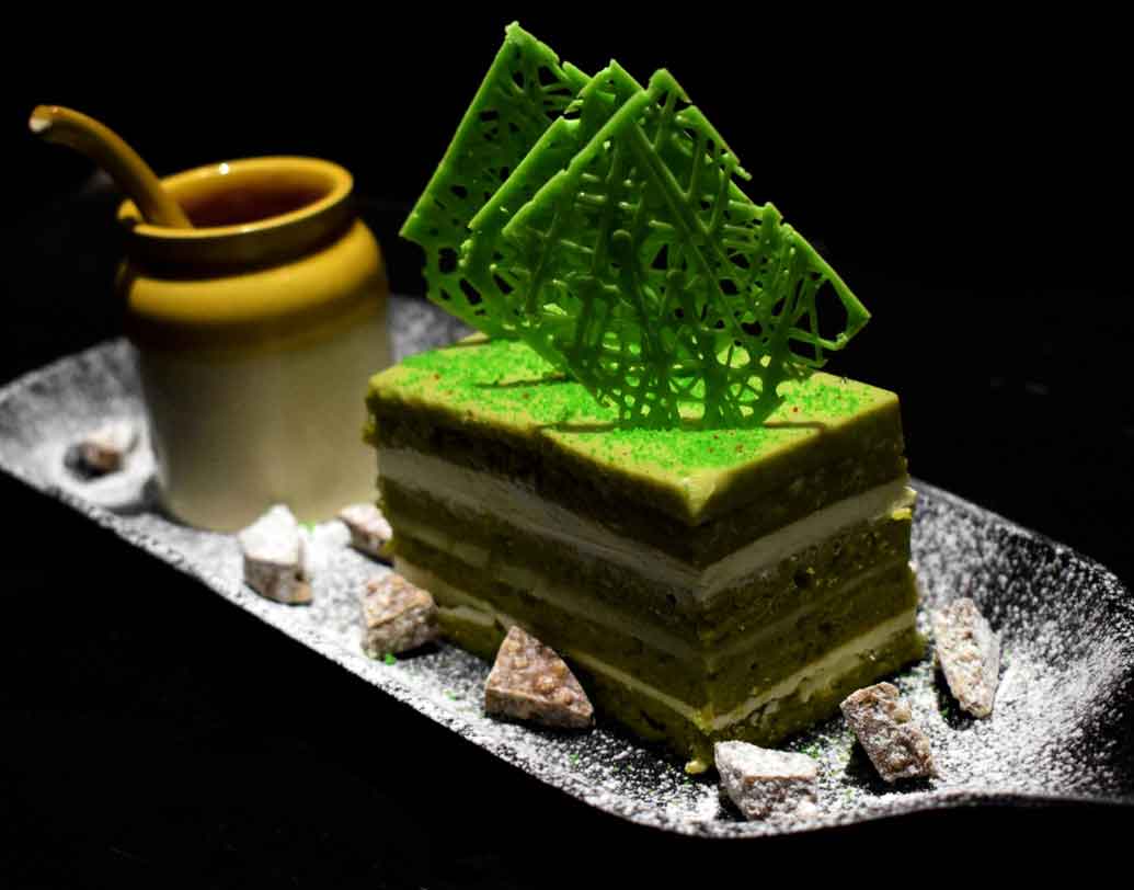 গ্রিন টি অপেরা কেক: গ্রিন টি’য়ের উপকারিতা আমরা প্রায় সকলেই জানি। কিন্তু গ্রিন টি দিয়ে বানানো কেক খেয়েছেন কি আগে? আদতে এটি একটি জাপানিস ডেসার্ট। আর জাপানের গ্রিন টি’য়ের মধ্যে রয়েছে গুরুত্বপূর্ণ ওষধি উপাদান। এই সুস্বাদু ডেসার্টটি খেতে চাইলে আপনার গন্তব্য হোক কলকাতা বিমানবন্দরের সন্নিকটে, হোটেল হলিডে ইন্‌ন।