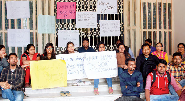 দাবি: এ ভাবেই উত্তরবঙ্গ বিশ্ববিদ্যালয়ের প্রশাসনিক ভবনের সামনে অবস্থান করে বসে থাকেন গবেষকরা। নিজস্ব চিত্র

