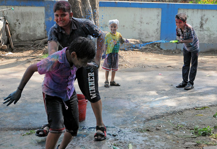 রংচঙে আমরা ক’জন। মিল্ককলোনি রেন্টাল আবাসনে দোলের রঙে কচিকাঁচারা।