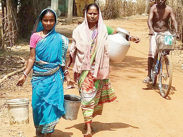 দুর্ভোগ: পানীয় জল আনতে কলসি-বালতি নিয়ে পাড়ি। খড়্গপুর গ্রামীণের ঘোলঘোড়িয়ায়। নিজস্ব চিত্র।