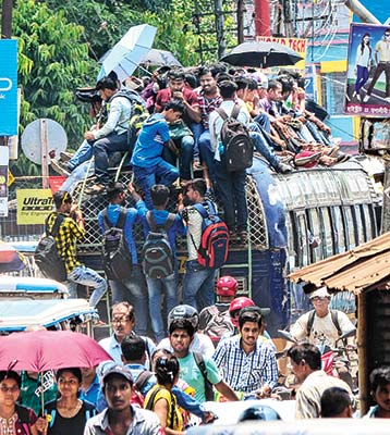 সংগ্রাম: রোদে পুড়ে, বাদুড়ঝোলা হয়ে এ ভাবেই চললেন চাকরিপ্রার্থীরা। কৃষ্ণনগরে। ছবি: সুদীপ ভট্টাচার্য