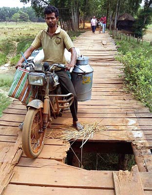 People are in danger as they fave to cross a wooden bridge
