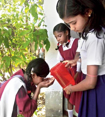 পাশে: এক স্কুলের ছাত্রীর তৃষ্ণা মেটাচ্ছে অন্য স্কুলের বন্ধু। নিজস্ব চিত্র