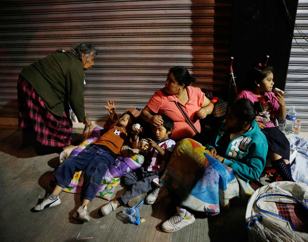 তখনও ভয় কাটেনি। শহরের রোমা এলাকার বাসিন্দারা নিজেদের ঘরবাড়ি ছেড়ে রাস্তাতেই আশ্রয় খুঁজছেন। ছবি: এপি।