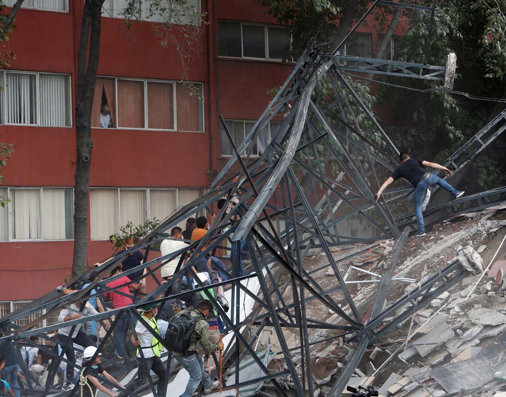 ধ্বংসস্তূপ এড়িয়ে নিরাপদ আশ্রয়ের খোঁজে এগিয়ে চলেছেন শহরবাসীরা। ছবি: রয়টার্স।