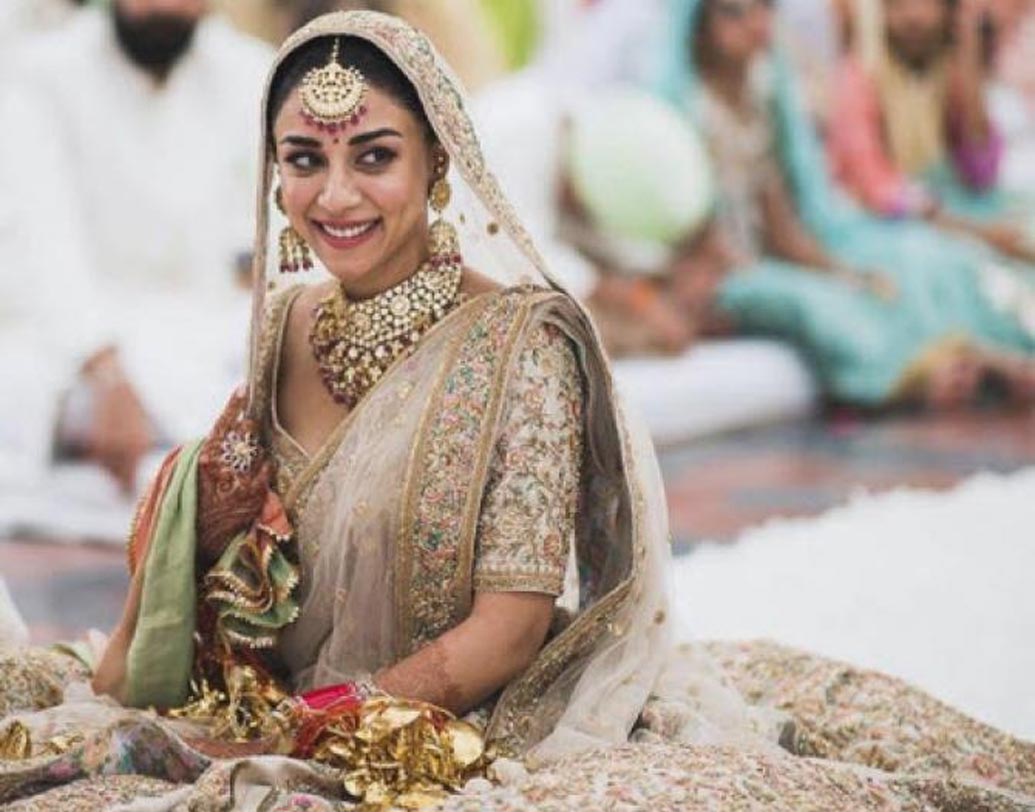আগে বিয়ের কনে সাদা বা অফ হোয়াইট পোশাক পরবেন শুনলে অনেকেই নাক সিঁটকোতেন। এখন বিয়ের কনেকে এলিগ্যান্ট লুক দিতে ডিজাইনাররা সাদা বা অফ হোয়াইটকেই বেস রং করতে চাইছেন। অমৃতা পুরির বিয়ের লেহঙ্গায় ছিল মাল্টি সুতোর এমব্রয়াডারি। গোল্ড এমব্রয়ডারিও সাদা বা অফ হোয়াইট পোশাককে দারুণ সুন্দর করে তোলে।