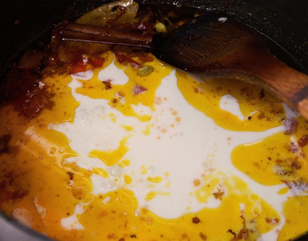 আঁচ কমিয়ে কড়াইতে ফেটানো দই দিয়ে ভাল করে নাড়তে থাকুন।