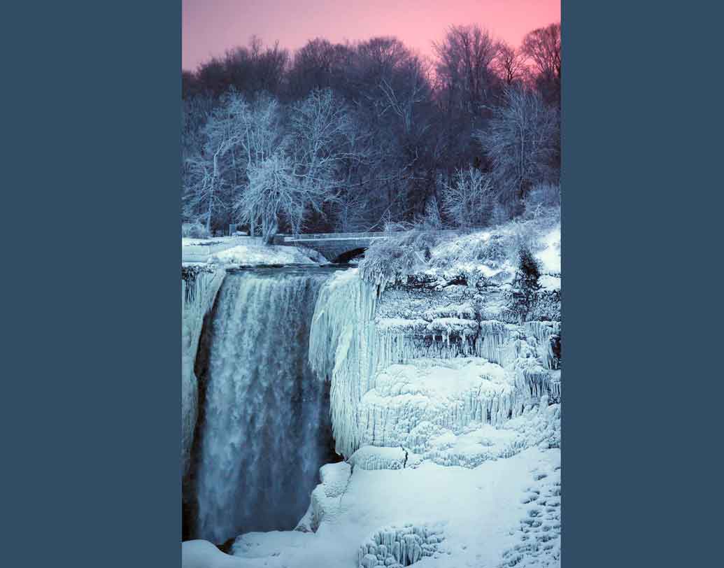 জমে যাওয়া জলপ্রপাতের ছবি ইতিমধ্যেই ভাইরাল সোশ্যাল মিডিয়ায়। ছবি: রয়টার্স।