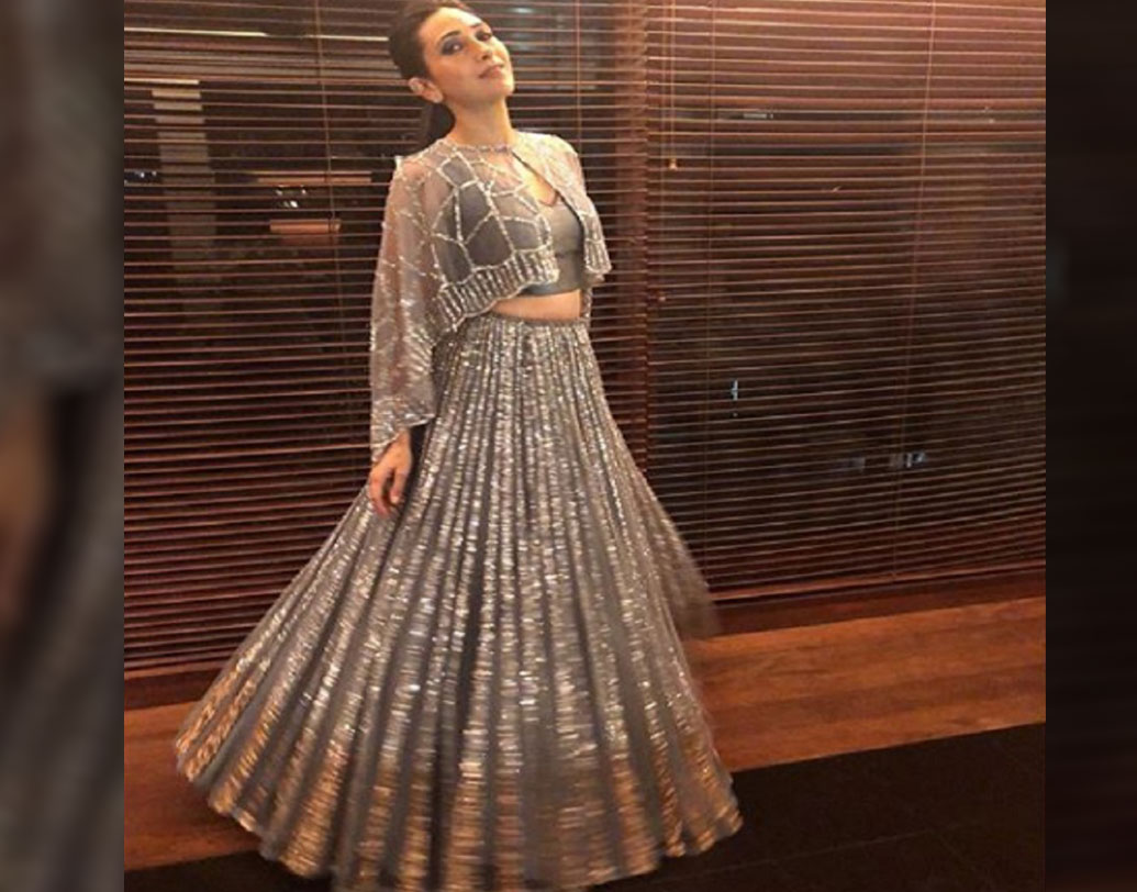 ভারতীয় পোশাক পরলেই তো আর হল না। সকলের মধ্যমণি হয়ে উঠতে হবে। তাই রূপোলি জরির কাজ করা ধূসর রঙের লেহঙ্গা ও সাদামাটা ধূসর চোলির উপর ফিনফিনে একটা জ্যাকেট চড়িয়েছেন করিশ্মা। ছবি: করিশ্মা কপূরের ইনস্টাগ্রাম পেজ থেকে সংগৃহীত।