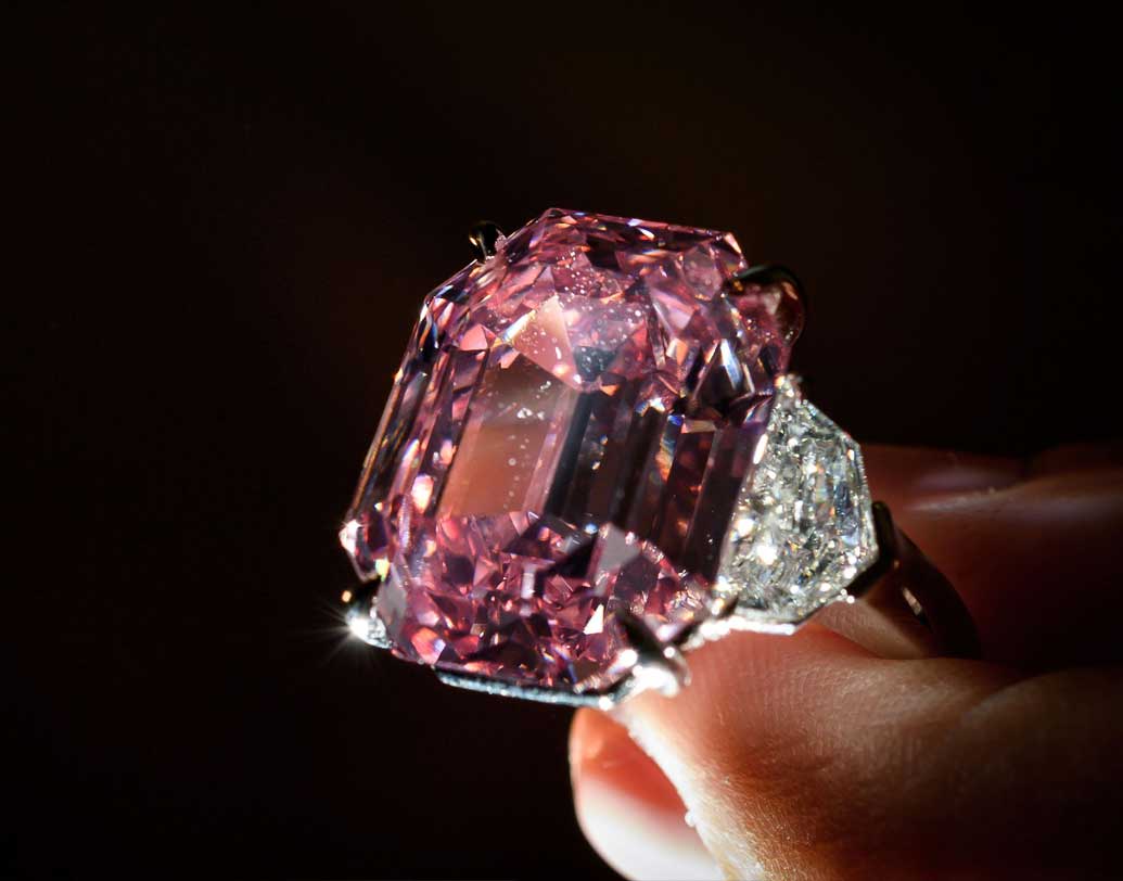 তাঁর মতে, ১৯২০ সাল নাগাদ এই হীরকখণ্ডটিকে কেটে ১৯ ক্যারেটের ওজন দেওয়া হয়। আগামী ১৩ তারিখ পৃথিবীর সেরা এই হিরের কত দাম ওঠে তা নিয়ে আধীর আগ্রহে অপেক্ষায় রত্নব্যবসায়ী ও বিশেষজ্ঞরা। ছবি: এএফপি ও শাটারস্টক।