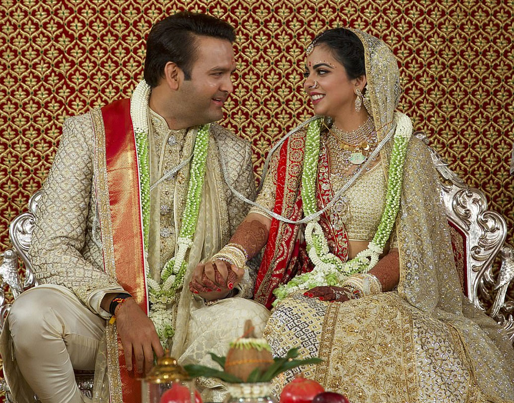 ঈশার বিয়ের পোশাক কিন্তু সব্যসাচী বা মণীশ মলহোত্রর ডিজাইনে তৈরি নয়। একেবারে অন্যরকম এক আবেগের ছোঁয়া রয়েছে এতে। অফ হোয়াইট লেহেঙ্গায় সি গ্রিন এমব্রয়ডারি ছিল ঈশার পোশাকে। আনন্দের পোশাকটিও ছিল তেমনই। তবে সঙ্গে ছিল সোনালি রঙের সাফা দোপাট্টা।