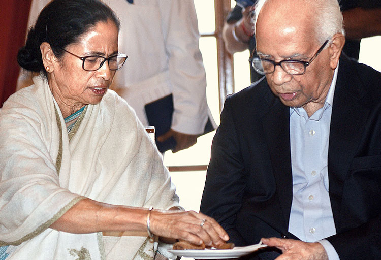 সৌজন্য: নতুন মন্ত্রীদের শপথগ্রহণের পরে চা চক্রে রাজ্যপাল কেশরীনাথ ত্রিপাঠীর প্লেটে খাবার তুলে দিচ্ছেন মুখ্যমন্ত্রী মমতা বন্দ্যোপাধ্যায়। বৃহস্পতিবার রাজভবনে। ছবি: সুমন বল্লভ।