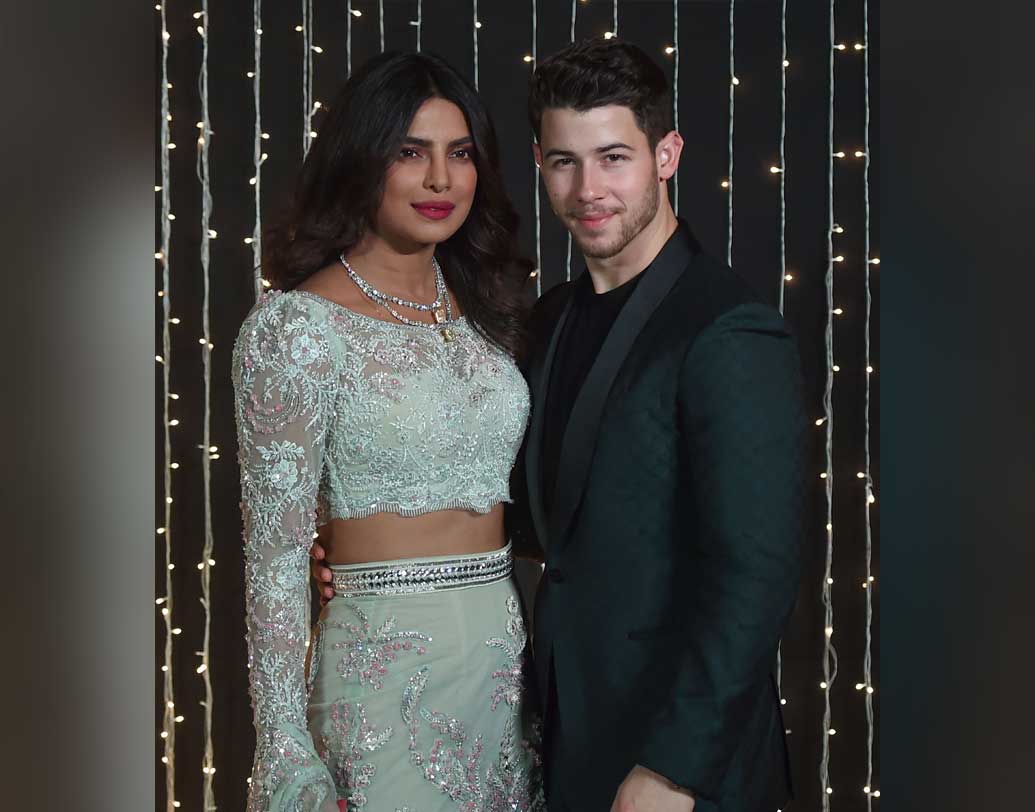 নিক ও প্রিয়ঙ্কা দু’জনেরই রিসেপশনের সাজ ছিল চোখ ধাঁধানো! সাদা শিফনের স্কার্টের উপর লেস, সুতো ও জরির কাজ ও একই নকশার টপে প্রিয়ঙ্কা হয়ে উঠেছিলেন অনন্যা। উল্টো দিকে জমকালো ব্লু শেডেড স্যুটের নিকের দিক থেকেও চোখ ফেরানো দায় হয়ে উঠেছিল।