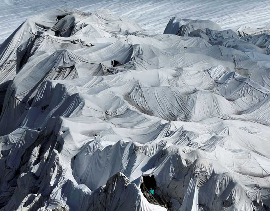 সুইৎজারল্যান্ডের ফুরকায় রোন হিমবাহের বরফের গুহার পাশে এক মহিলা দাঁড়িয়েছিলেন। সেই ছবিটি তোলা হয়। ছবিটি দেখে অনেকেই দুধ সাদা কাপড়ে মোড়া তাঁবুর সারি ভেবেছিলেন।