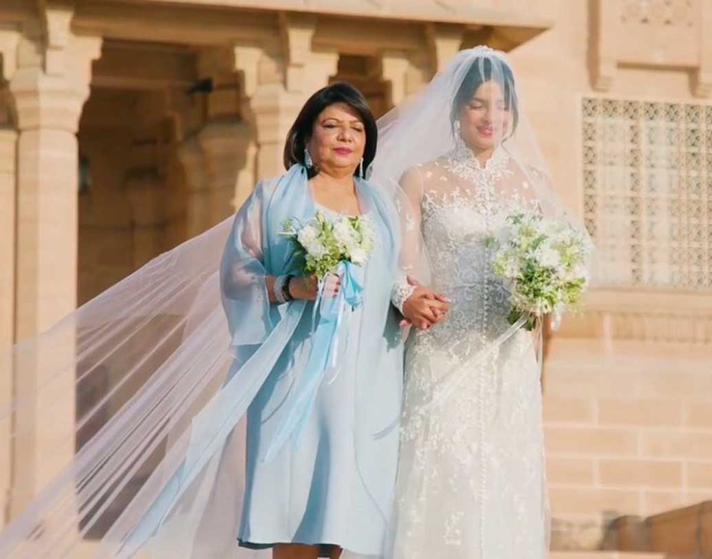 প্রিয়ঙ্কার বাবা অশোক চোপড়া প্রয়াত হয়েছেন। তাই মা মধু চোপড়াই মেয়েকে নিকের হাতে তুলে দেন। খ্রিস্টান বিয়েতে মেয়ের মতো তিনিও পশ্চিমী পোশাকই বেছে নেন। ছবি: টুইটার থেকে সংগৃহীত।