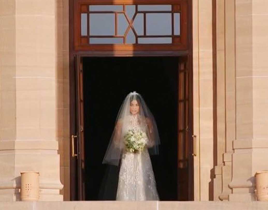 শ্বেত-শুভ্র সাদা গাউনে প্রিয়ঙ্কা একাই অবশ্য উমেদ ভবন থেকে বেরিয়ে আসেন। সিঁড়ি দিয়ে কয়েক ধাপ নেমে এলে তাঁর হাত ধরেন মা মধু চোপড়া। তার পর সবুজ ঘাসের উপর দিয়ে বিবাহস্থলের দিকে এগিয়ে যান তাঁরা। ছবি: টুইটার থেকে সংগৃহীত।