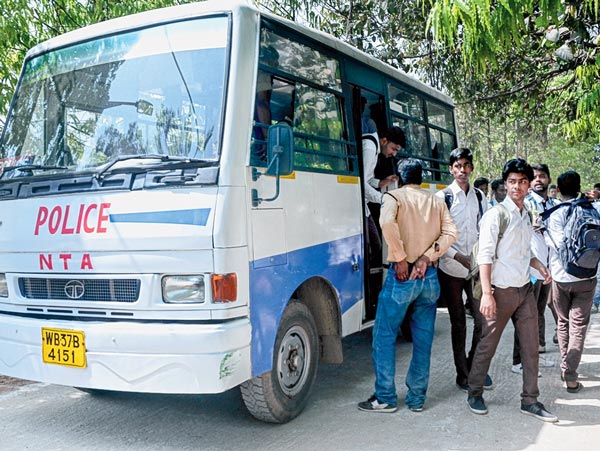 পুলিশের গাড়ি থেকে নামছেন পরীক্ষার্থীরা। আসানসোলের ধাদকা এনসি লাহিড়ী স্কুলে। বৃহস্পতিবার। নিজস্ব চিত্র