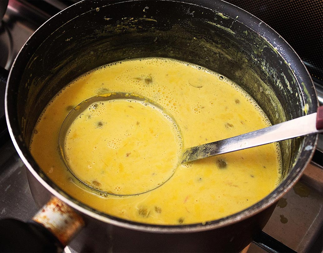 এ বার চিনি, কনডেন্সড মিল্ক, পেস্তা কুচি ও হলুদ রং মিশিয়ে আরও ২ মিনিট হালকা আঁচে রাখুন যতক্ষণ না চিনি সম্পূর্ণ গলে যাচ্ছে।