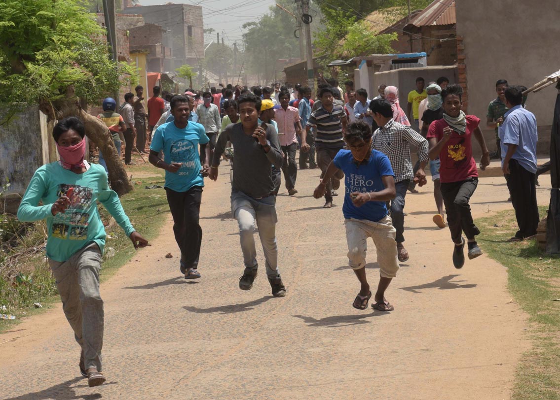 পিছনে চলছে বোমাবাজি। ছুটে আসছে মানুষ। তাদের কয়েকজনের হাতে রয়েছে ইট। পরিচয় গোপন রাখতে মুখে শক্ত করে বাধা রুমাল।