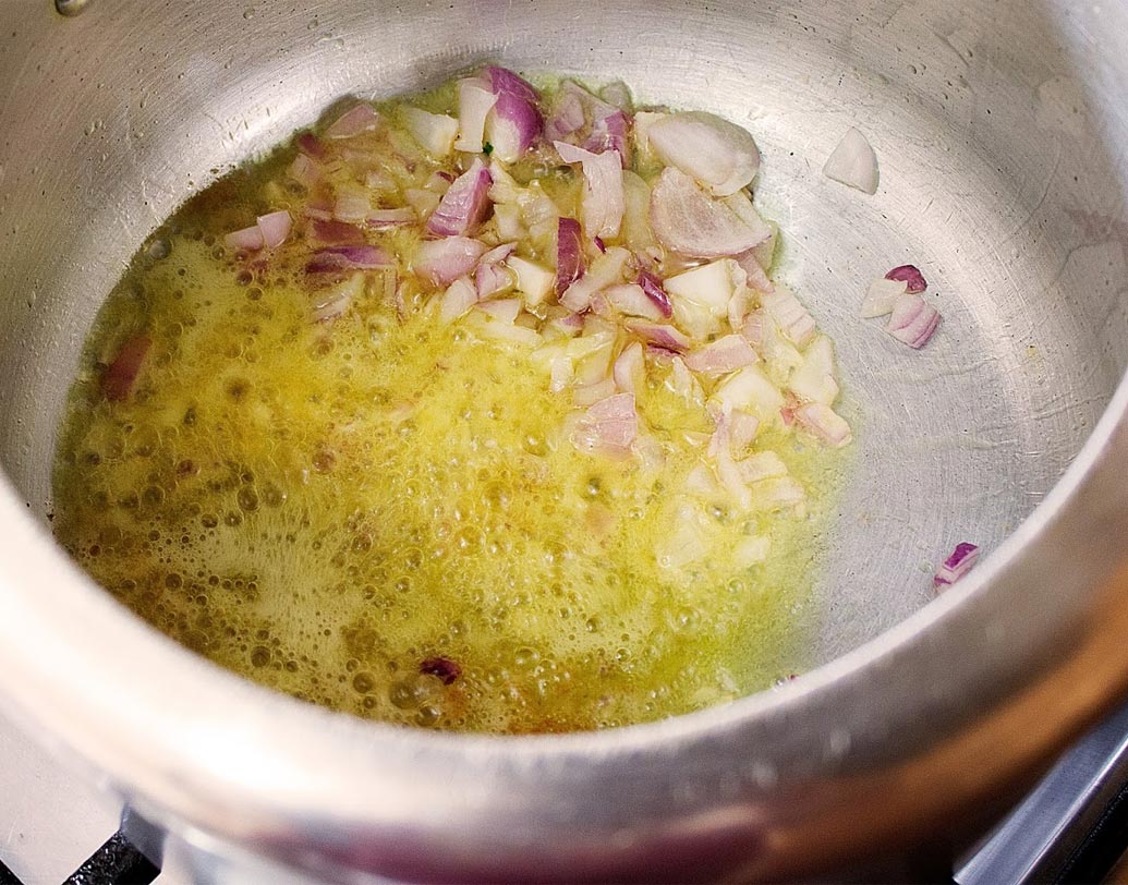 প্রেশার কুকারে ১ টেবল চামচ ঘি গরম করুন। পেঁয়াজ কুচি দিয়ে নাড়তে থাকুন।