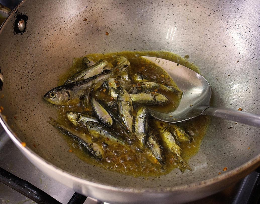 চুনো মাছ ১ চা চামচ হলুদ গুঁড়ো আর নুন দিয়ে ম্যারিনেট করে রাখুন ১০ মিনিট। এ বার বেগুন ভাজা তেলে মাছ দিয়ে সোনালি করে ভেজে নিন।