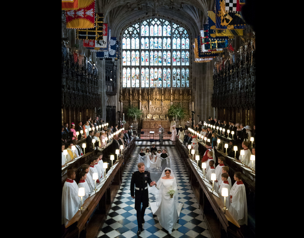 চার হাত এক হল। বিয়ের পর সেন্ট জর্জ’স চ্যাপেল থেকে বেরিয়ে আসছেন হ্যারি এবং মেগান মার্কল। ছবি: রয়টার্স।