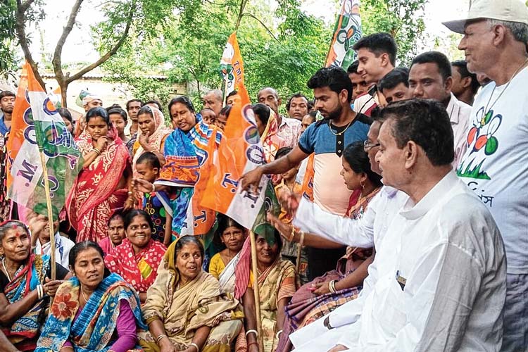 মাঝে: গ্রামবাসীর সঙ্গে পাড়া বৈঠকে মন্ত্রী স্বপন দেবনাথ। পূর্বস্থলীর নাদনঘাটে ভোটের প্রচারে। ছবি: জাভেদ আরফিন মণ্ডল