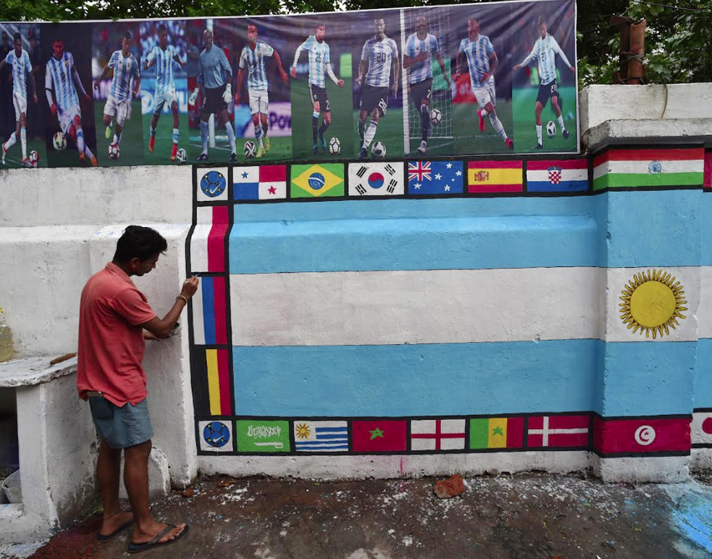 ওপরে আর্জেন্তিনার ফুটবলারদের নানা ছবি। নানা ভঙ্গিতে বল পায়ে মেসি। রয়েছেন, অন্যান্যরাও। তার নিচে ৩২ দেশের লোগো। আর মাঝখানে আর্জেন্তিনার পতাকা। চলছে শেষ মুহূর্তের কাজ। রাত জাগার প্রস্তুতিও প্রায় শেষ। এবার শুধু ঢাকে কাঠি পড়ার অপেক্ষা। কাউন্টডাউন আর কয়েক ঘন্টার। গোটা বিশ্ব মেতে উঠবে বল-পায়ে ।