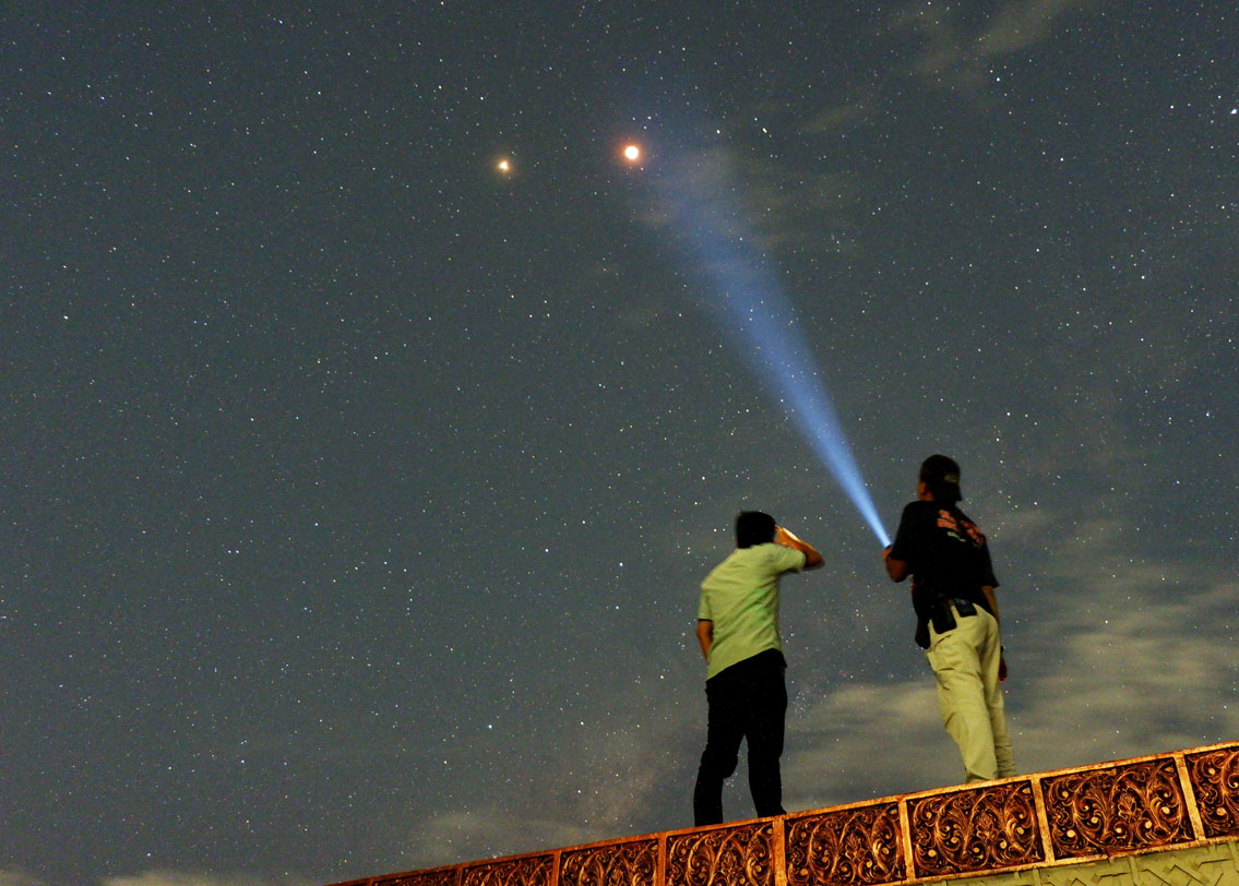 ইন্দোনেশিয়ার সুমাত্রা দ্বীপ। চাঁদের পাশেই জ্বলজ্বল করছে মঙ্গলগ্রহও। চাঁদের পাশাপাশি মঙ্গলকে এত কাছে দেখার সুযোগ ছিল এ বারে। পৃথিবীর এত কাছ থেকে লাল গ্রহ মঙ্গলকে দেখার সুযোগ ফের পাবেন সেই ২২৮৭-র ২৮ অগস্ট এবং ২৭২৯ সালে। ছবি: রয়টার্স।