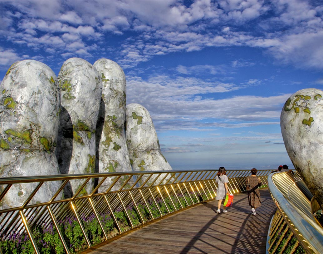 চমকে যাওয়ার কিছু নেই। আসলে ভিয়েতনামের দুর্গম পাহাড়ি এলাকার শহর দানাং, আর তাতেই গড়ে উঠেছে সোনালি রঙের ঝলমলে সেতু। এই সেতুকে ধরে রেখেছে দু’টি বিশালাকার হাত, একেই বলা হচ্ছে ঈশ্বরের হাত।
